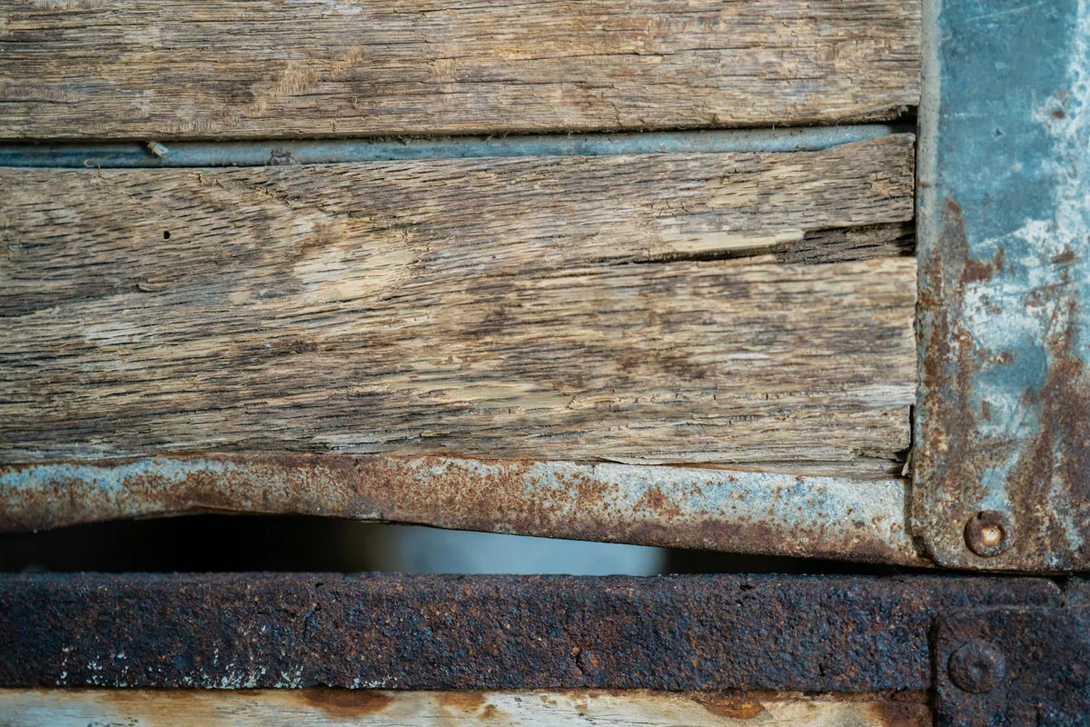 Detailed view of an old wooden surface with rusty metal, showing textures and wear.