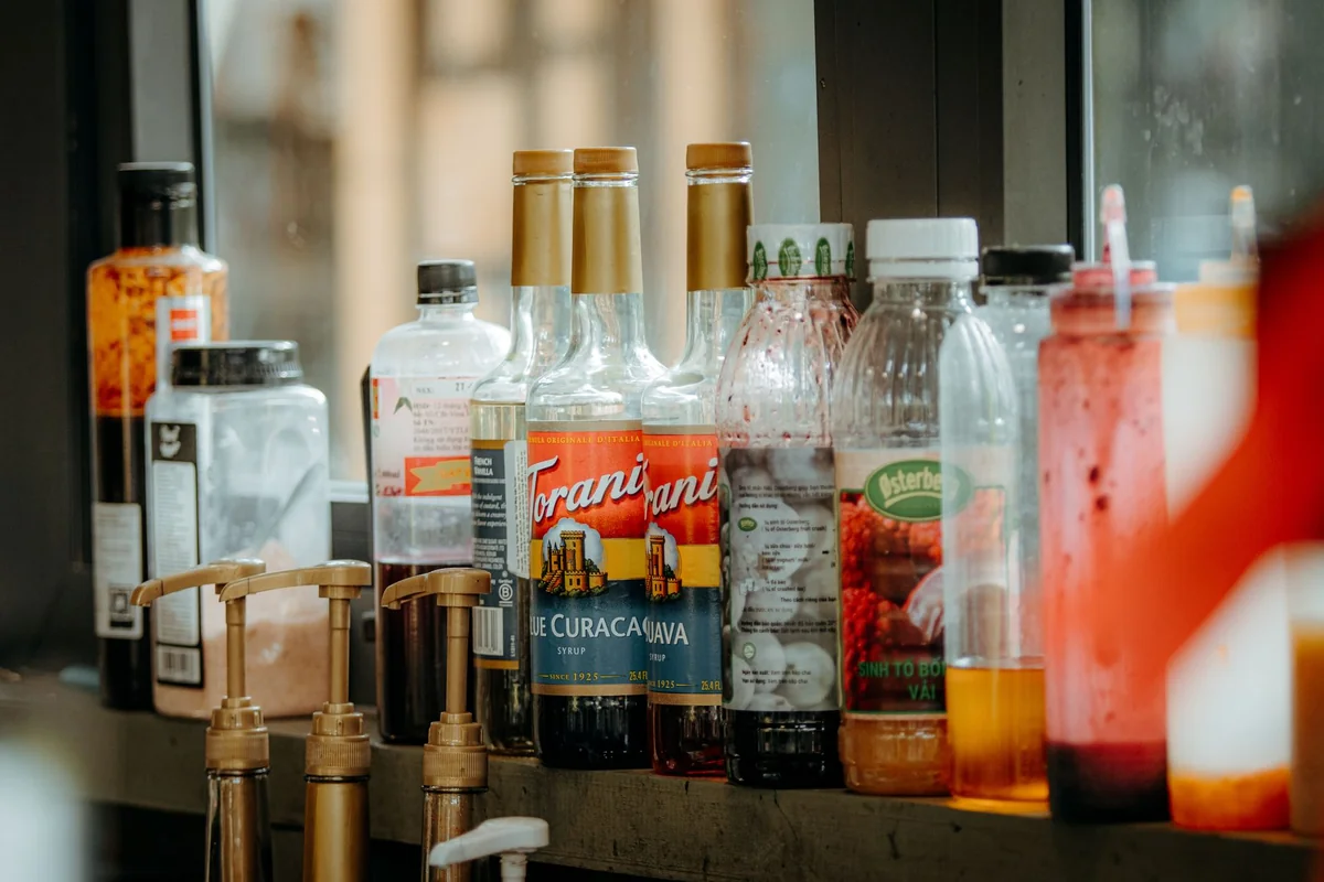 Domáci ríbezľový sirup v sklenenej fľaši s čerstvými ríbezľami