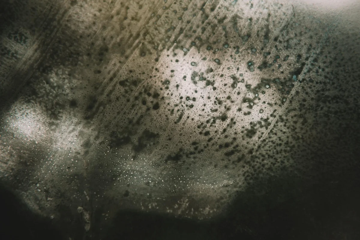 Mysterious abstract image featuring textured surface and light reflections creating a moody atmosphere.
