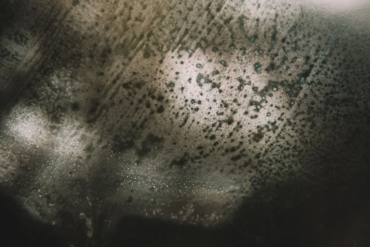Mysterious abstract image featuring textured surface and light reflections creating a moody atmosphere.